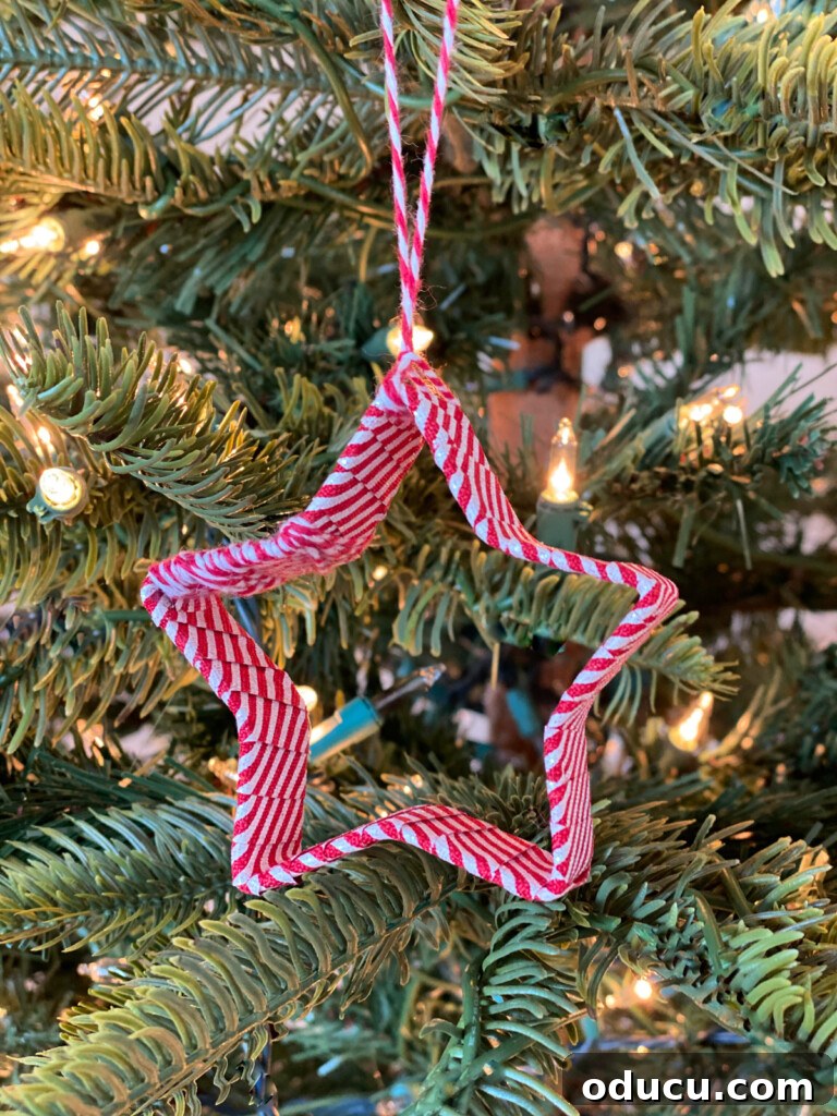 Red and white striped ribbon covering a star cookie cutter to make an Christmas tree ornament.