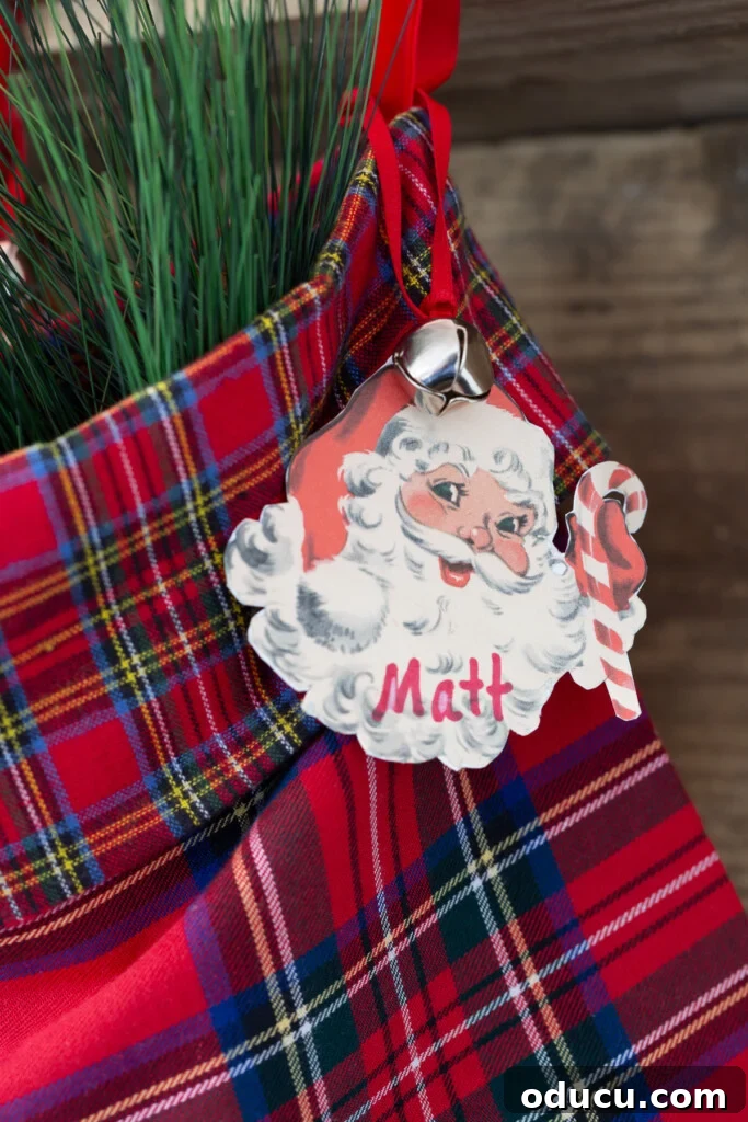 Craft Your Own Christmas Stocking Guide 6 close up of a vintage Santa face tag on a red plaid stocking hanging from a mantel.