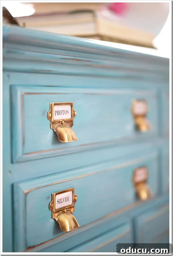 Instant Brass Patina: A 5-Minute Method 15 Finished brass label holders and drawer pulls from Van Dyke's Restorers on a turquoise sideboard, demonstrating a complete makeover.