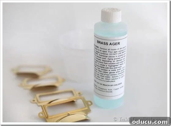 Instant Brass Patina: A 5-Minute Method 6 Bottle of Brass Ager solution next to several brass pulls, ready for the aging process.