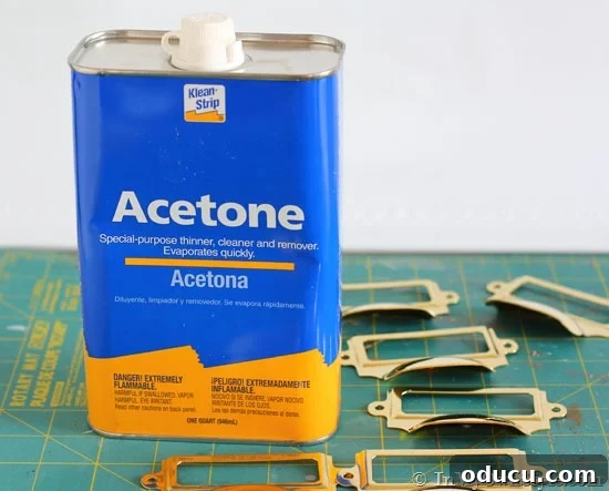 Instant Brass Patina: A 5-Minute Method 4 Bottle of acetone next to brass pulls on a work table, illustrating the lacquer removal process.