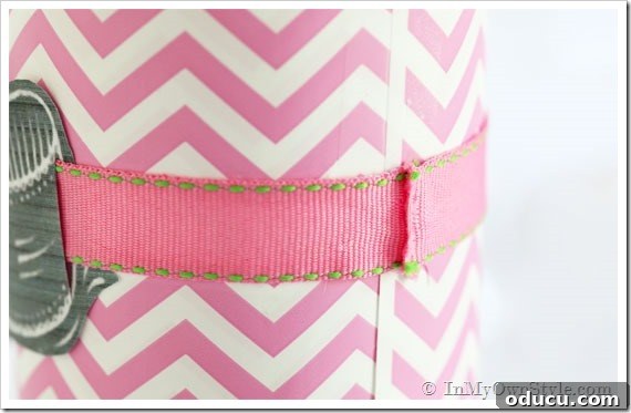 Step-by-Step Wine Bottle Wrap with Ribbon and Tag Close-up of a wine bottle with ribbon threaded through a gift tag, demonstrating the wrapping technique.