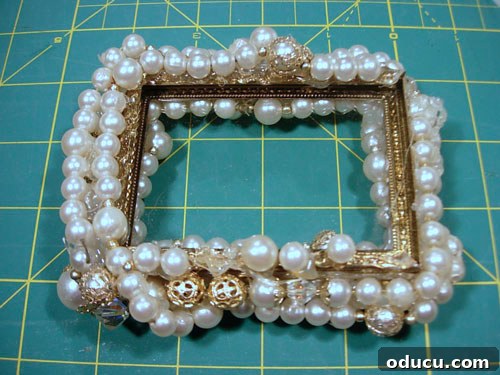Transform Vintage Frames into Unique Necklace Gifts 3 Applying the first layer of pearls with hot glue to a photo frame.