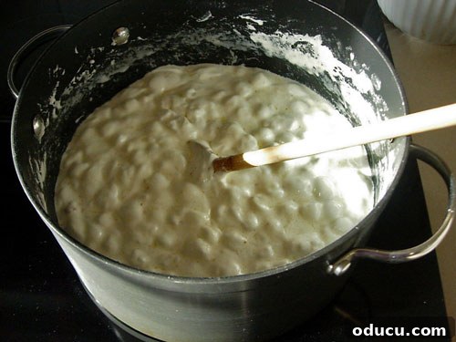 Popcorn-Cake-Marshmallow-Melting on stove Close-up of the marshmallow mixture bubbling gently in the pot, indicating it has reached the ideal consistency after boiling.