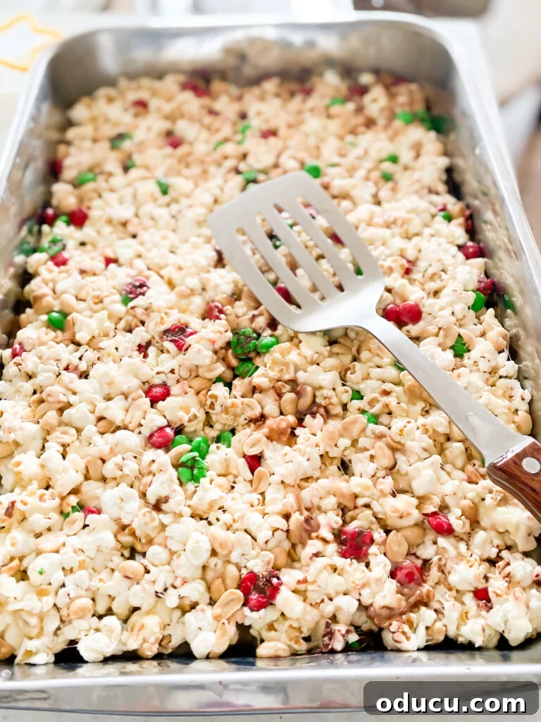 Festive Star Popcorn Cakes 4 Close-up of the popcorn mixture being firmly pressed into a baking tray, ensuring an even layer before cooling.