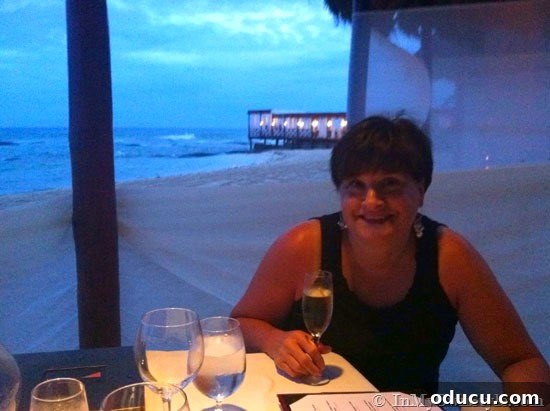 Diane at Candlelit Beach Dinner Diane enjoying a romantic candlelit beach dinner at El Dorado Royale, an unforgettable anniversary celebration.