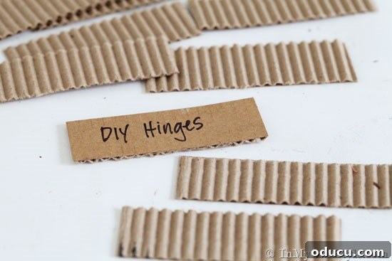 Upcycled Photo Frame Christmas Tree Skirt 11 A close-up image illustrating how to ingeniously craft hinges for a Christmas tree stand cover using repurposed corrugated cardboard, showcasing a practical DIY solution.