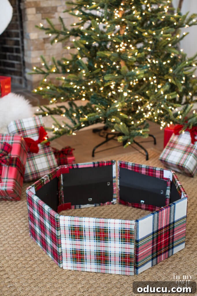 Upcycled Photo Frame Christmas Tree Skirt 16 The DIY Christmas tree collar, expertly crafted from fabric-wrapped frames, is neatly folded and ready to be placed around the Christmas tree stand, showcasing its flexible design.