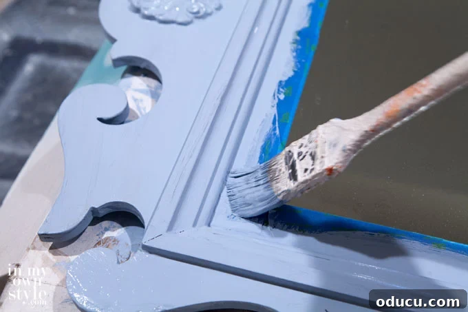 Unlock Amazing Furniture Makeovers with Homemade Chalk Paint 4 A decorative mirror frame being painted with light blue homemade chalk paint.