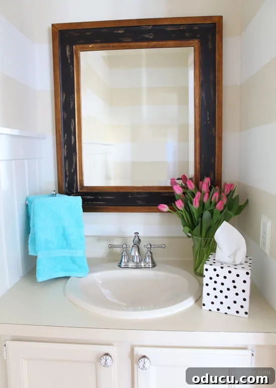 Instant Wall Decor: Hang Art & Mirrors Like a Pro 2 Decorating ideas for mirrors in a powder room, showing a stylish mirror over a sink.