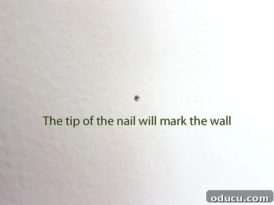 Instant Wall Decor: Hang Art & Mirrors Like a Pro 9 Tapping the top of the framed picture while holding the gadget to mark the wall.
