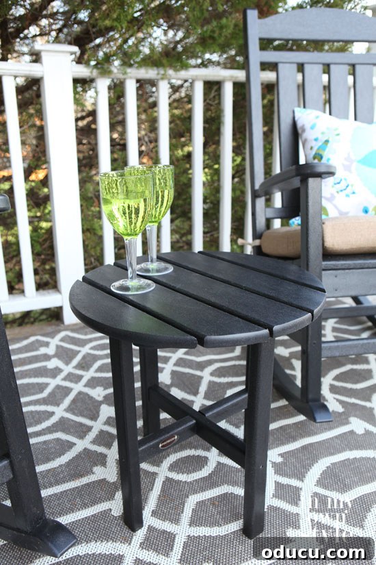 Polywood Presidential Rocker and Side Table: Unveiling Premium Outdoor Comfort 5 Decorated Polywood Presidential Rockers in black, with a stylish pillow and outdoor rug on a patio