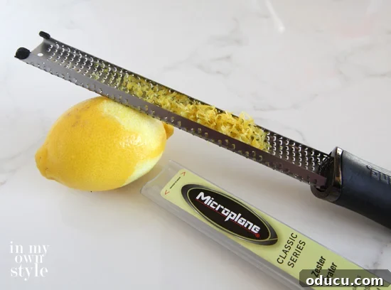 Demonstration of grating lemon peel using a zester for apple crisp recipe.