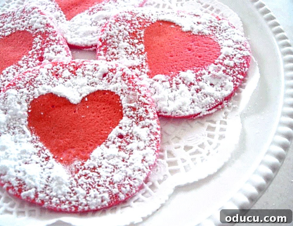Heartfelt Breakfast for Your Sweetheart 2 Red pancakes with powdered sugar hearts, perfect for Valentine's Day or a romantic breakfast in bed.