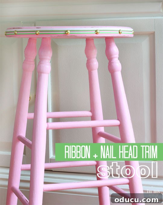 Ribbon Flair for Instant Home Style 11 Pink painted stool with ribbon and nail head trim around the edge of the seat, adding color and detail without extensive painting.