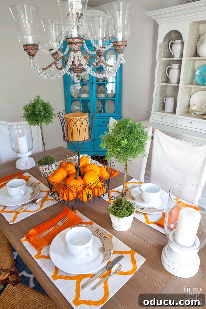 Effortless Autumn Pumpkin Decorating 20 An affordable yet elegant fall tablesetting featuring mini pumpkins and candles arranged in a wire basket, perfect for a Thanksgiving table.