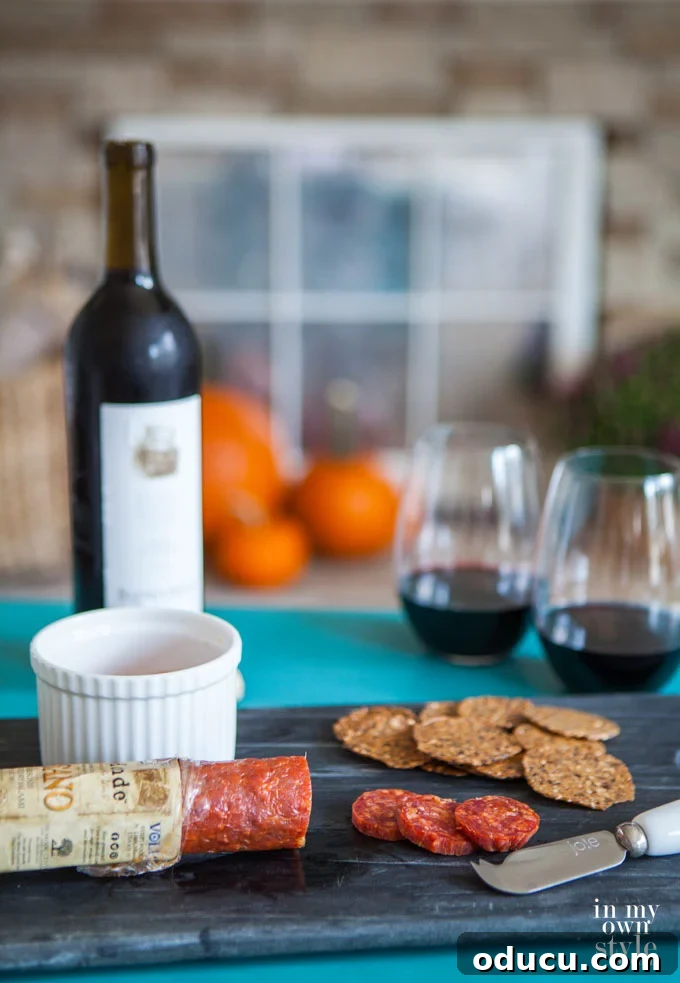 Effortless Autumn Pumpkin Decorating 5 A cozy autumn scene featuring a grouping of three varied-sized pumpkins on a fireplace hearth, perfectly complementing a wine and cheese setup.
