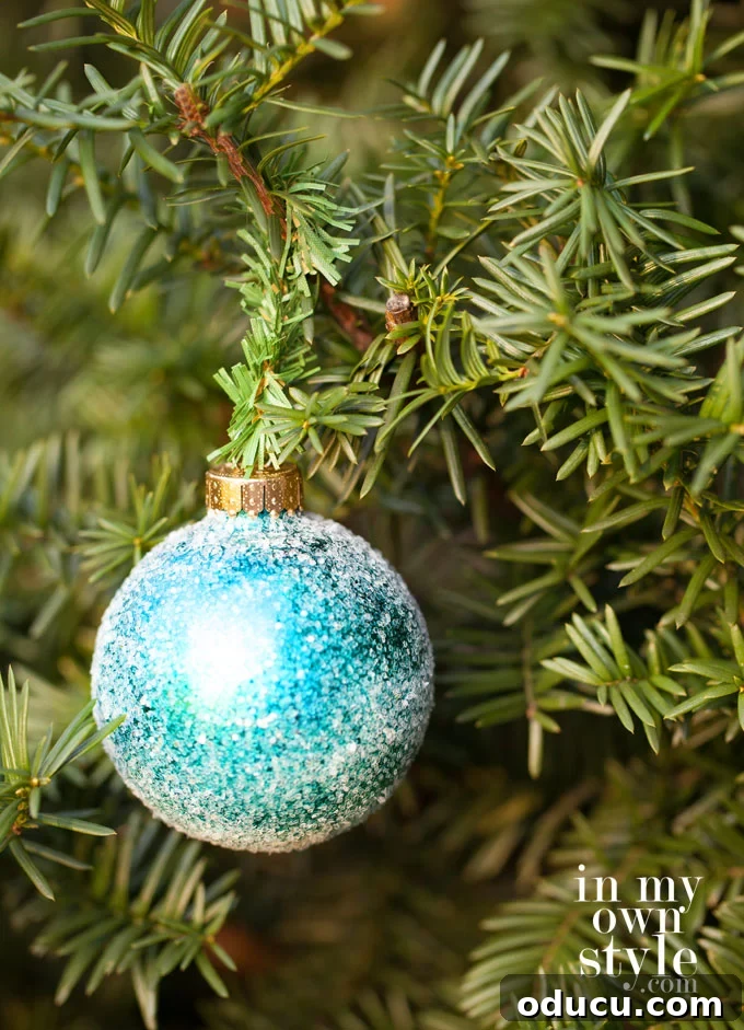 Christmas ornament hanging on a tree using a small section of a garland tie, perfectly hidden.