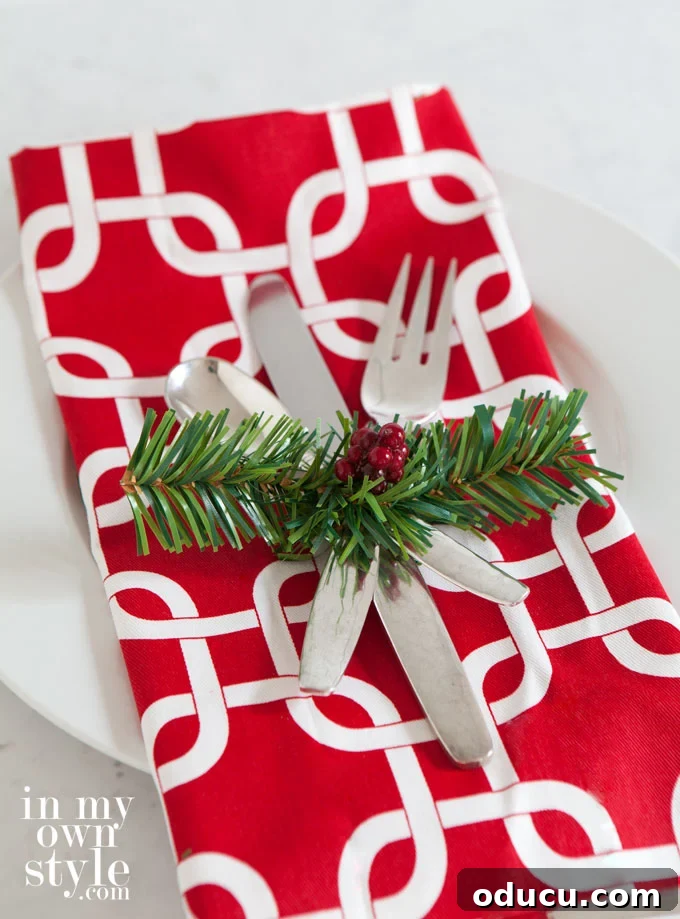 Christmas table setting idea using a garland tie and faux berries as a charming accent.