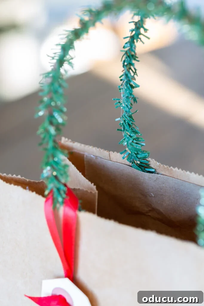 Close-up showing where to attach a pine garland tie to a gift bag to create a new handle.