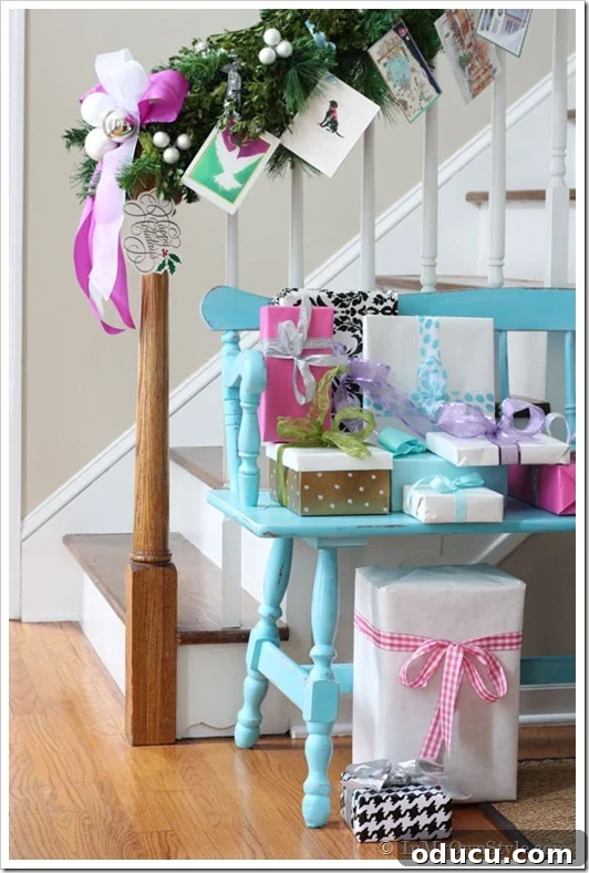 Christmas cards tied on staircase garland using ribbon and garland ties, blending seamlessly.