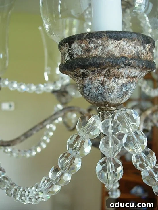 Achieve a Stunning Rusted Patina on Your Brass Chandelier 3 Close up of a chandelier with a textured rusted faux paint finish