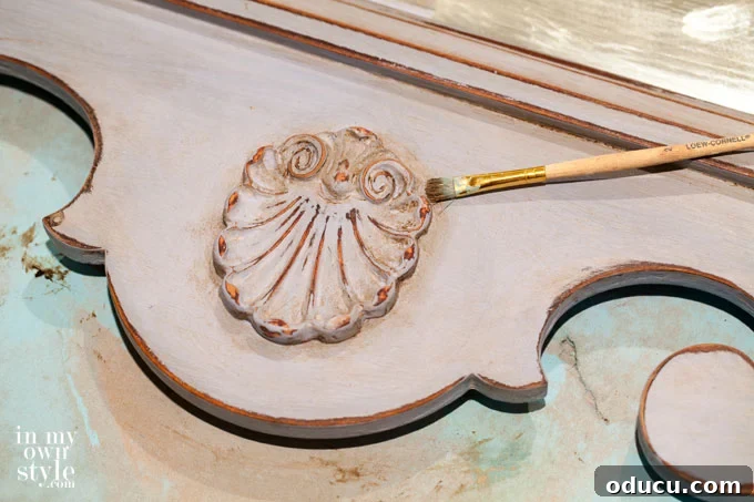 The Annie Sloan Secret to a Stunning Mirror Makeover 8 How to apply wax into furniture crevices using a small brush for detailed aging effects.