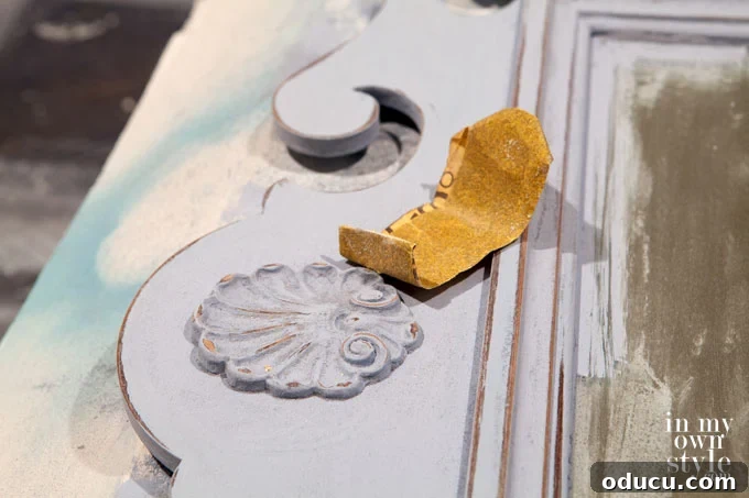 The Annie Sloan Secret to a Stunning Mirror Makeover 5 How to distress furniture with sandpaper, focusing on edges and details for an aged effect.