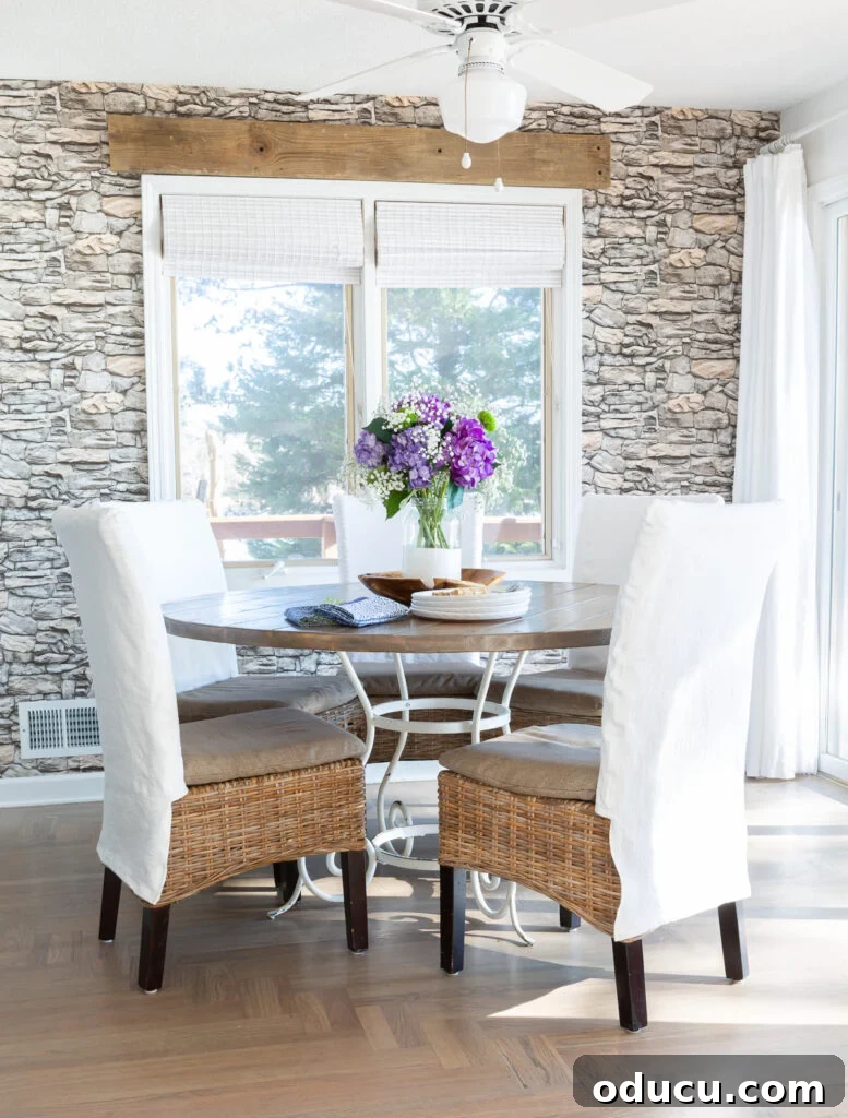 Transform Your Dining Chairs with Easy DIY Slipcovers 7 Kitchen table with 5 dining chairs around it each with a white slipcover. An inviting kitchen setup, where slipcovers bring unity and softness to the dining experience.