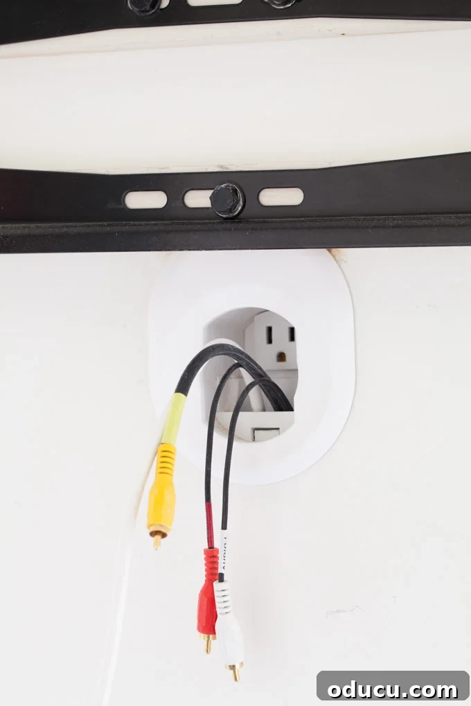 Wall-mounted-TV-cord-hiding-how-to-tutorial Wall-mounted-TV-cord-hiding-how-to-tutorial showing red and yellow cable wires coming out of wall under a TV wall mounting bracket.