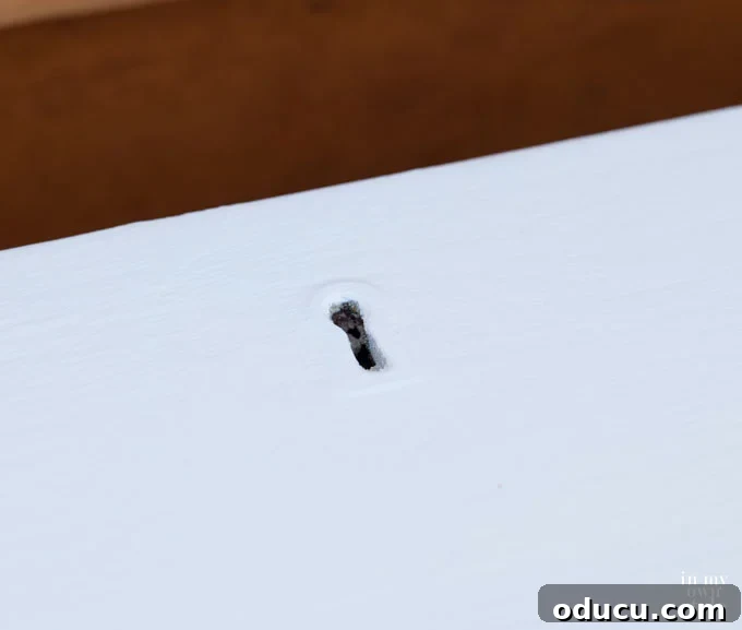 Detailed guide on how to paint a key hole on furniture for an antique brass look.