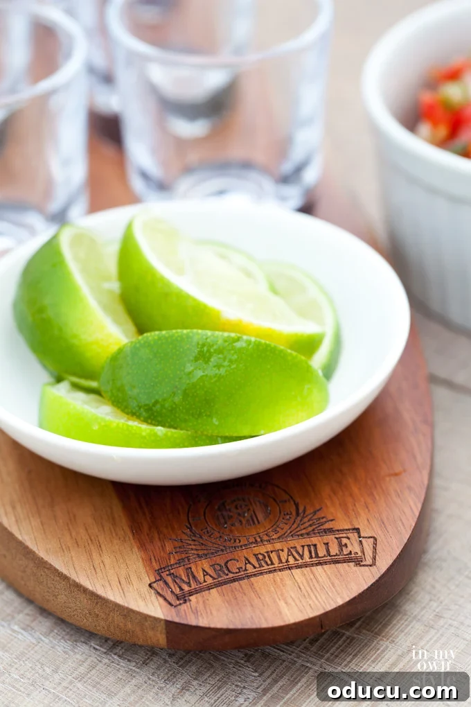 Crafting the Perfect Margarita 4 Stylish shot glass tray featuring a salt shaker and a small dish for lime wedges, ideal for summer party drinks.