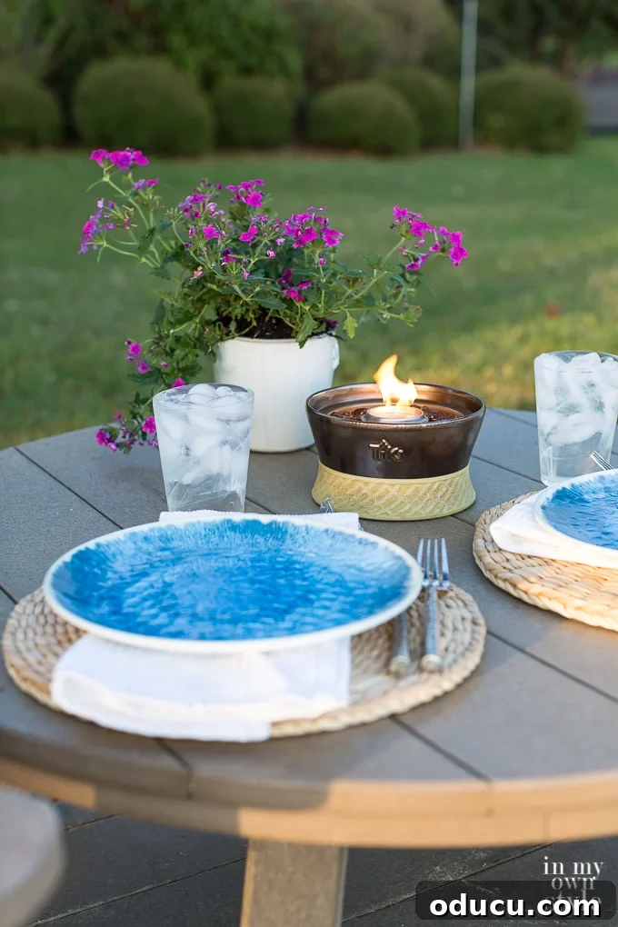 Outdoor Dining Done Right 2 small outdoor table set for one person with a drink and a plate, surrounded by greenery