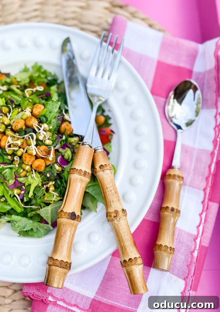 Outdoor Dining Done Right 5 white dinner plate with salad on a pink tray, with bamboo flatware for alfresco dining