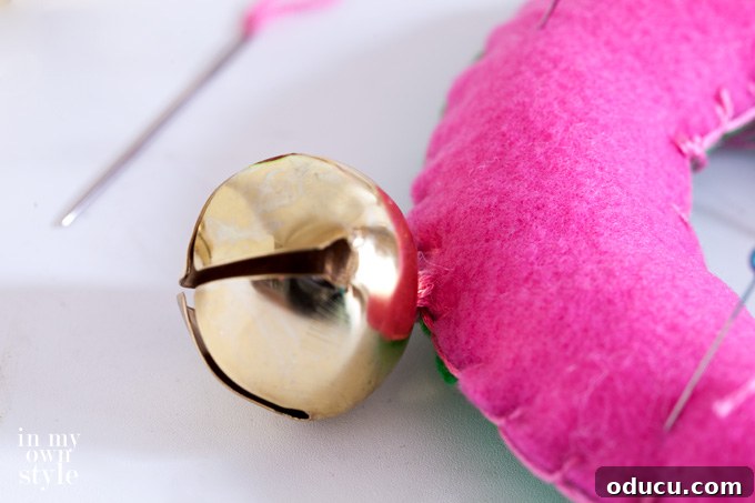 Christmas Door Knob Jingle 7 Securely sewing jingle bells onto the felt door hanger for a musical Christmas accent.
