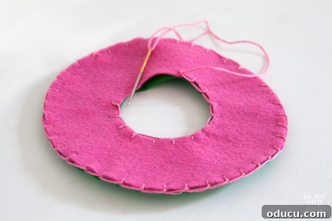 Christmas Door Knob Jingle 4 Sewing felt circles together using a blanket stitch for a jingle bell door hanger.