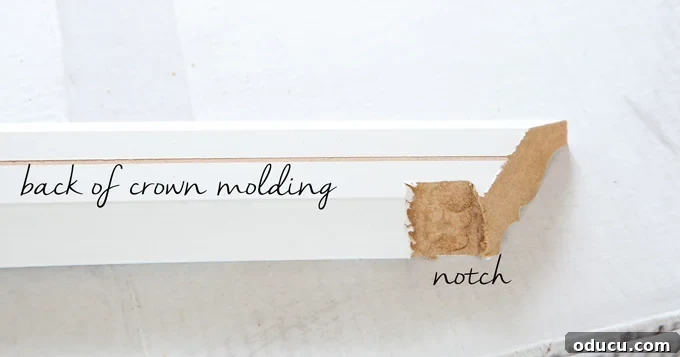 Mudroom Makeover: DIY Wall Cabinet Installation 5 Close-up showing the process of marking a notch on the back of crown molding for a flush fit.