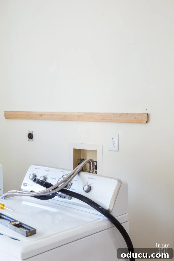 Mudroom Makeover: DIY Wall Cabinet Installation 2 Image showing a temporary 2x4 ledger board installed on the wall at the desired cabinet height.