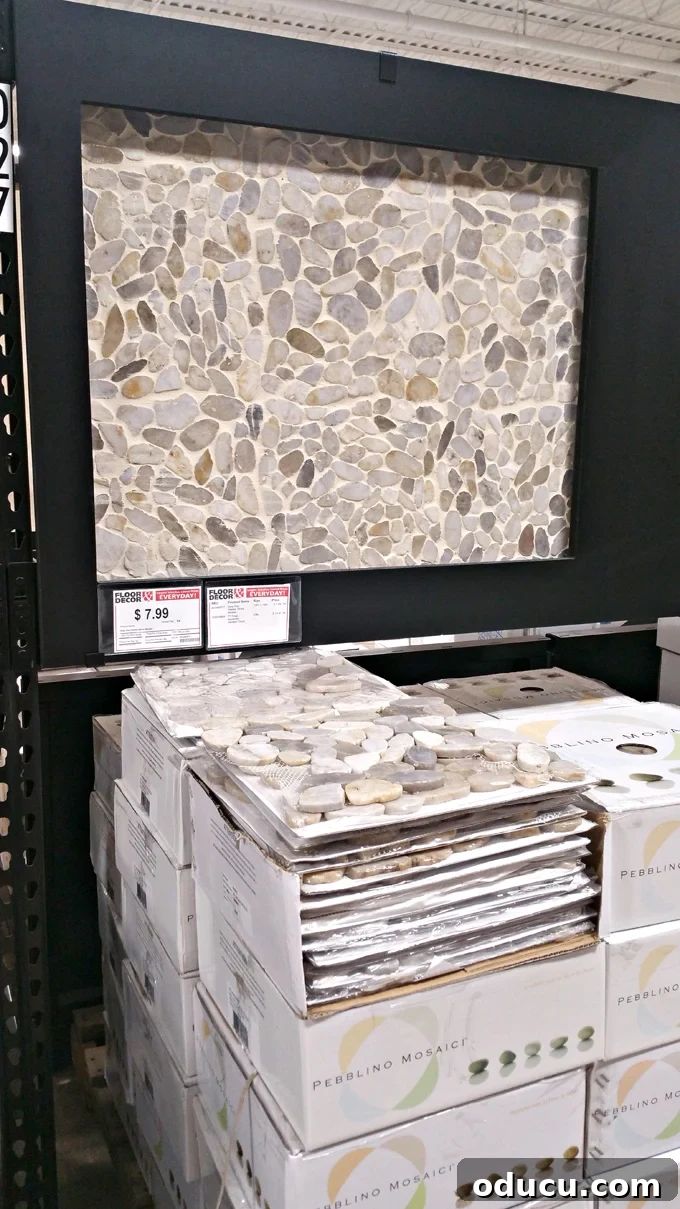 Luxury Master Shower Transformation 5 Display of round stone pebble mosaic tiles at Floor and Decor, showcasing natural textures and colors perfect for a spa-inspired shower.