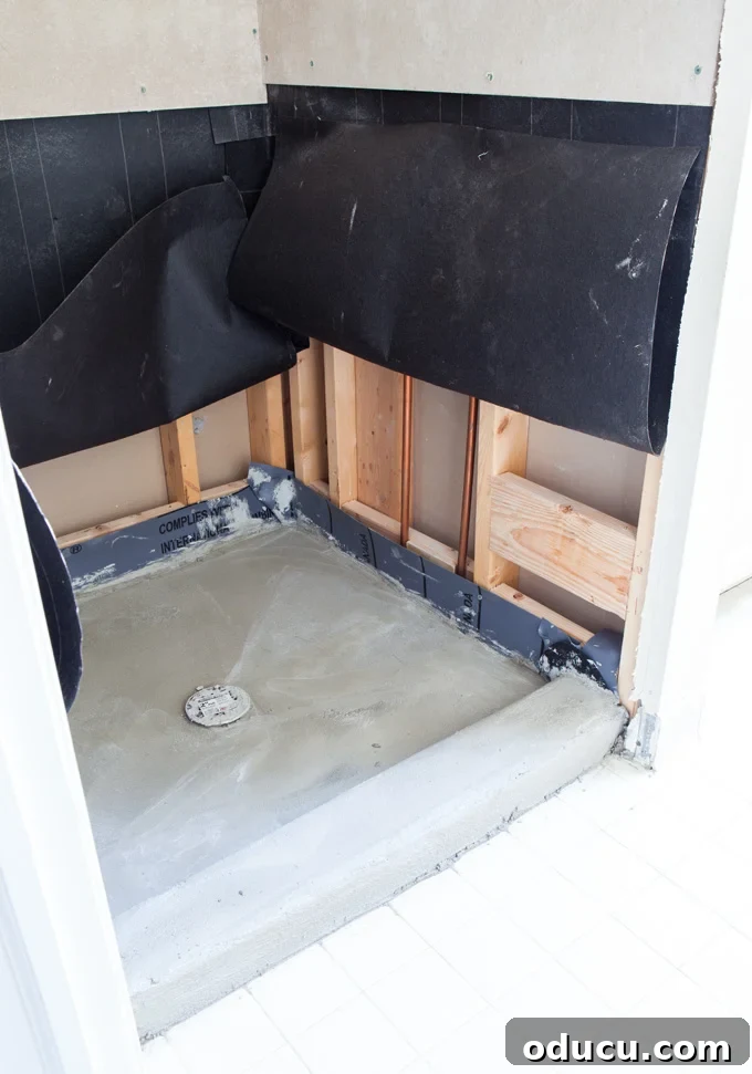 Luxury Master Shower Transformation 10 Detailed image of a wet bed being constructed for a tile shower, showing the sloped mortar base essential for proper drainage.