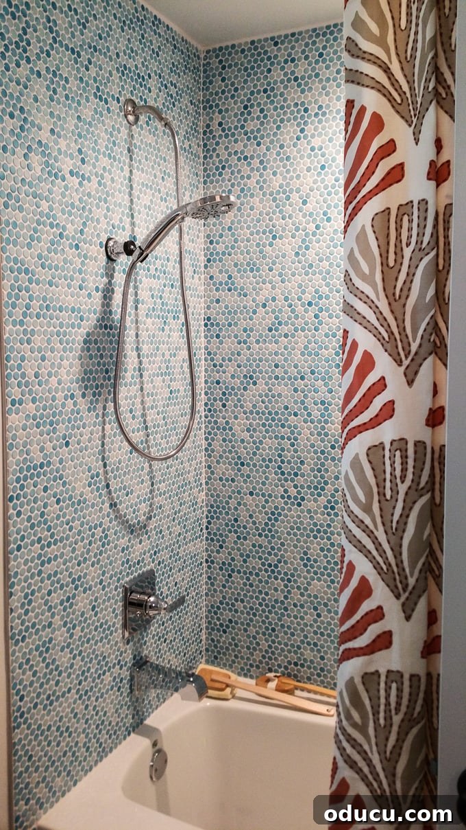 Step Inside the HGTV Dream Home 2016 17 A stylish bathroom with multi-toned turquoise blue penny tiles, reflecting the coastal charm of the HGTV Dream Home 2016.