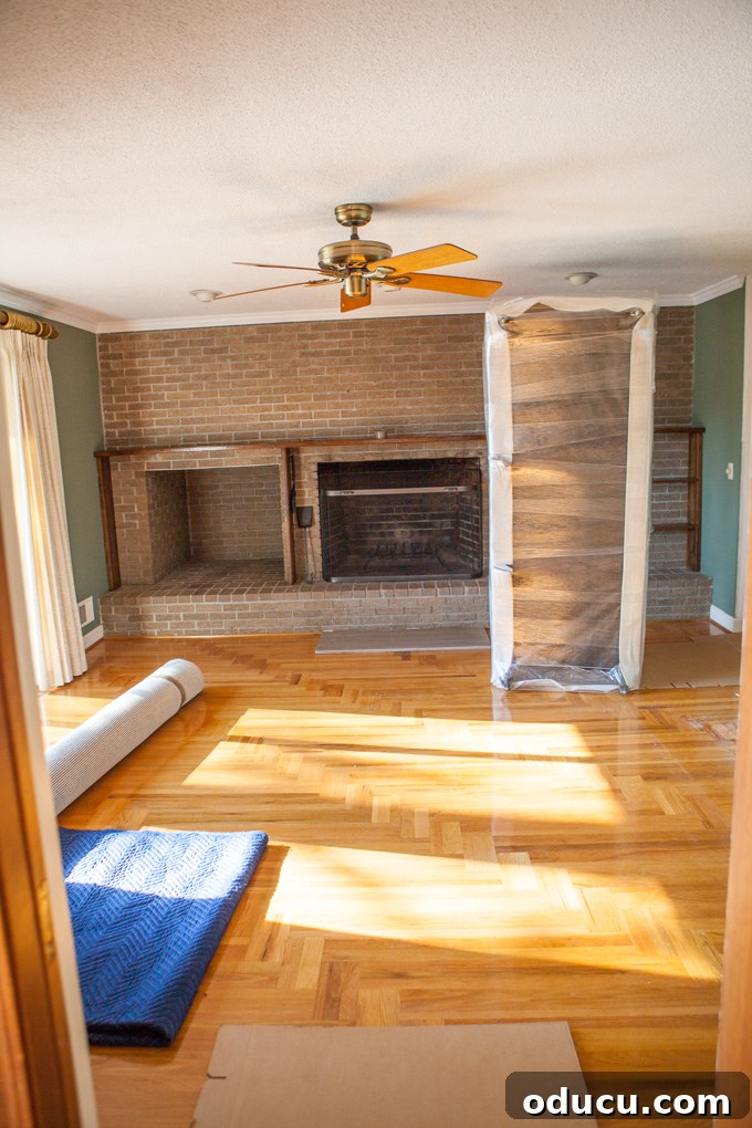 A Glimpse Inside My Brand New Home 10 Living room before renovation, with a brick fireplace, brown shelves, and a ceiling fan.