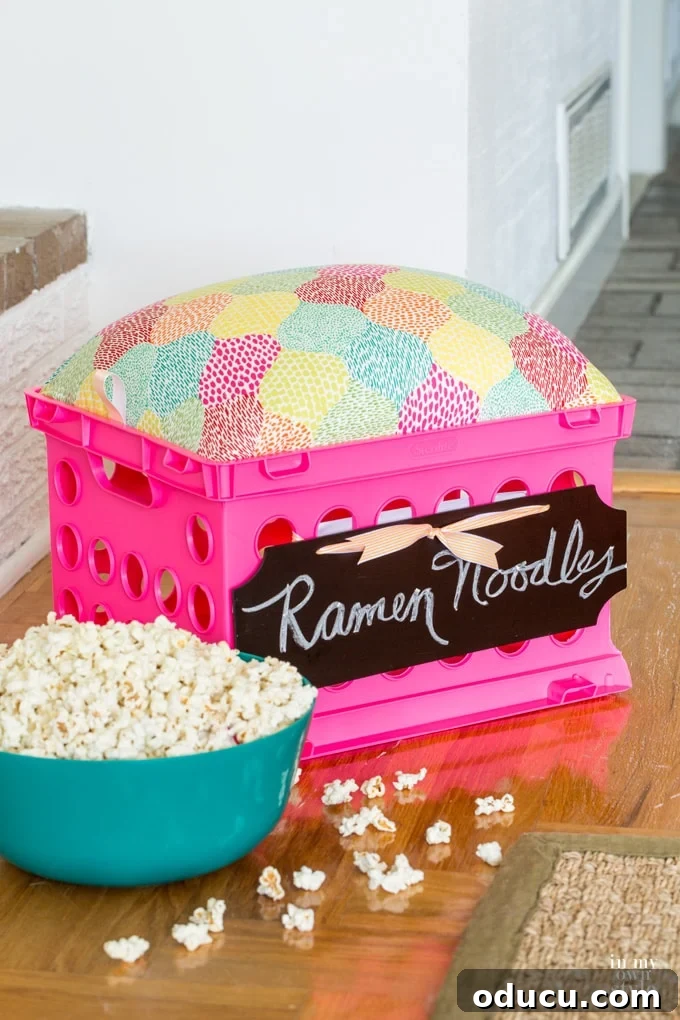 College dorm room storage idea using a stacking storage crate with a pink cushion