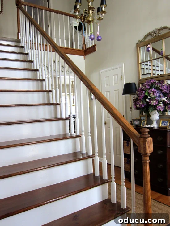 Staircase-makeover-After-2 After photo of a beautifully refinished staircase with stained wood treads and white painted risers