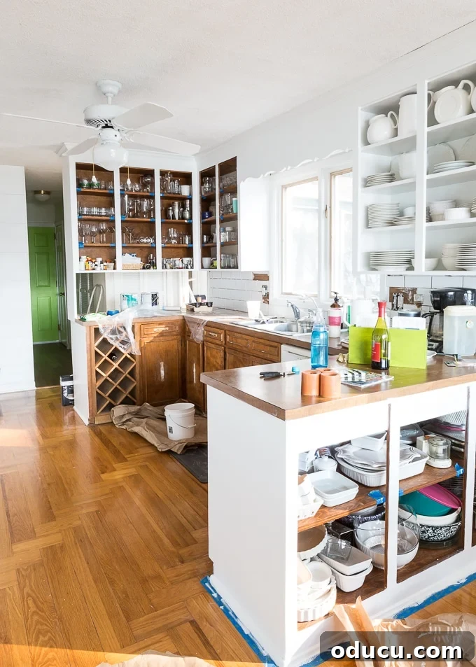 A kitchen makeover in progress, showcasing freshly painted cabinets and new hardware installation.
