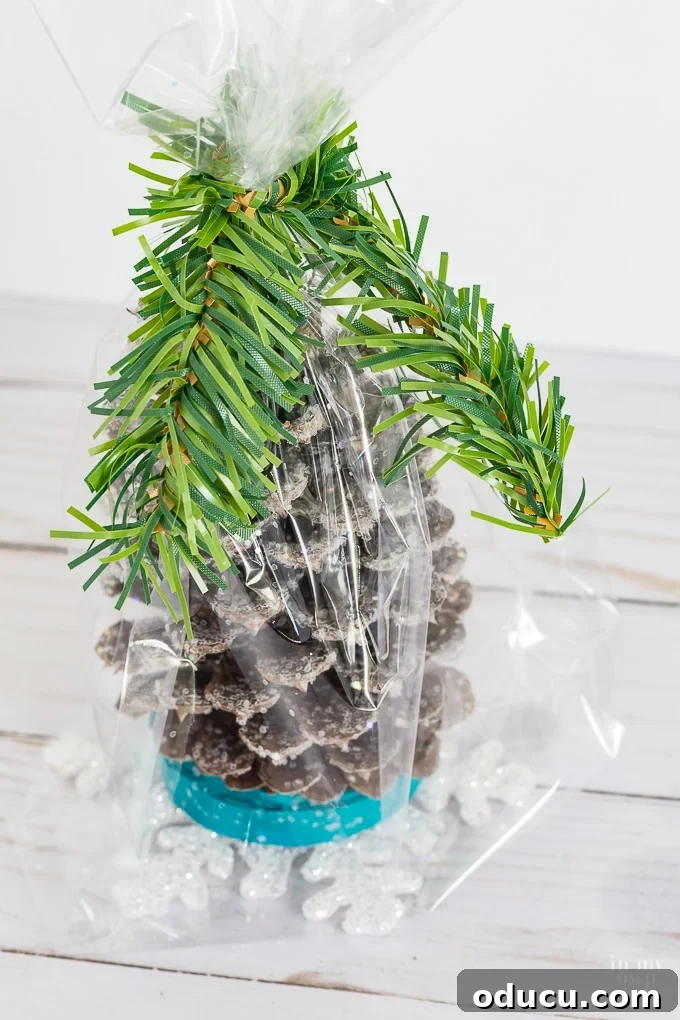 Vibrant Fragrant Holiday Pinecone Creations 18 Cinching the top of the gift bag closed with a festive pine garland tie for a secure and decorative seal.