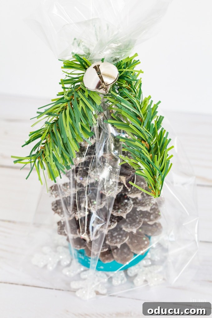 Vibrant Fragrant Holiday Pinecone Creations 19 Attaching a small jingle bell to the gift bag's garland tie with florist wire for a final festive accent.