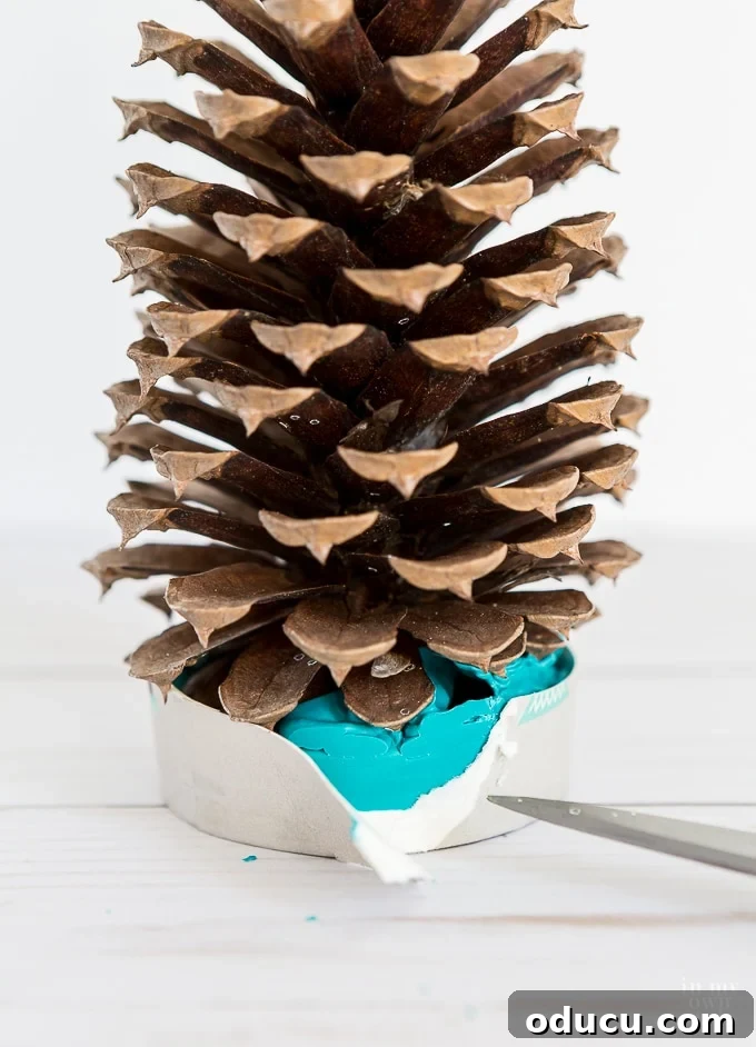 Vibrant Fragrant Holiday Pinecone Creations 10 Method for carefully removing the paper cup from the completely hardened wax base of the pine cone tree.
