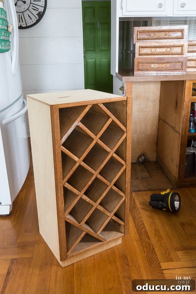 Kitchen Remodel: The Home Stretch 4 Close-up of a built-in kitchen wine rack before painting, showing its dark wood finish