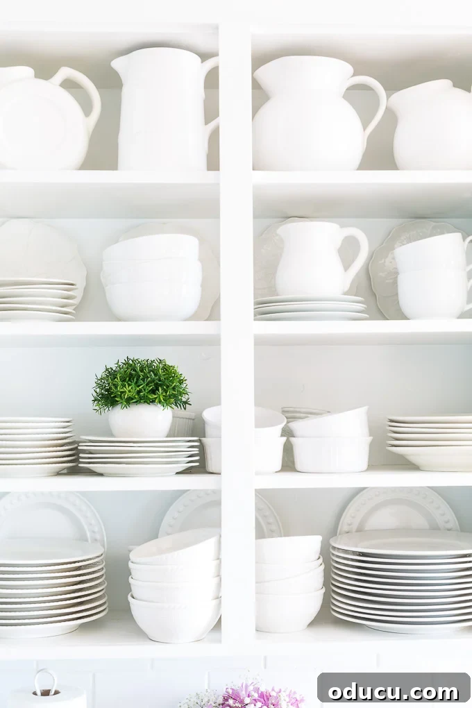Cozy Winter Interiors: Cultivate Calm and Rejuvenation 5 White kitchen shelves with an elegant collection of white dishes and pitchers